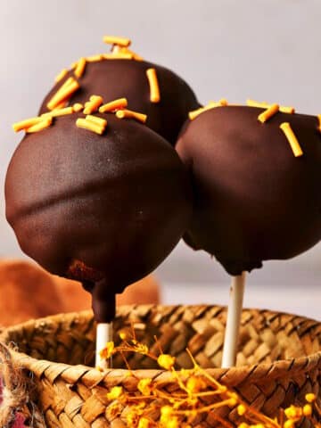 Pumpkin cake pops in small basket.