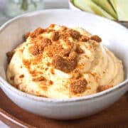 Pumpkin fluff dip in a bowl with crushed Biscoff cookies.