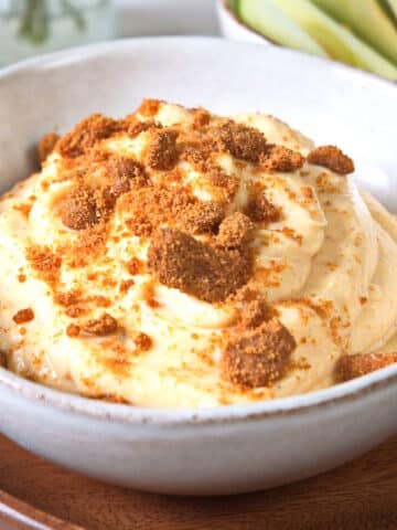 Pumpkin fluff dip in a bowl with crushed Biscoff cookies.