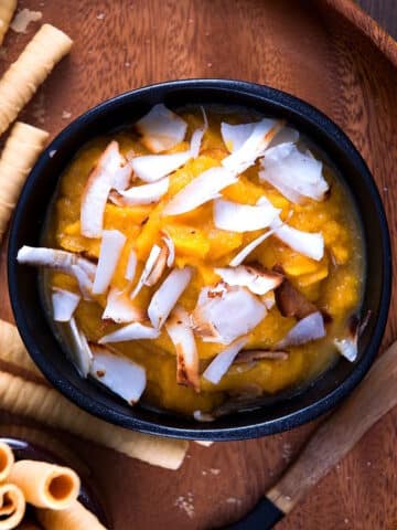Pumpkin pie dessert hummus in black bowl with sweet biscuits on the side.