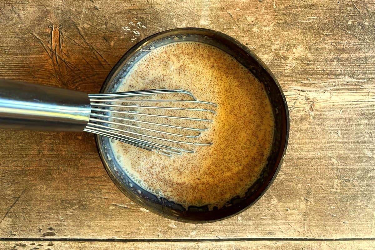Pumpkin spice creamer ingredients in bowl with whisk.