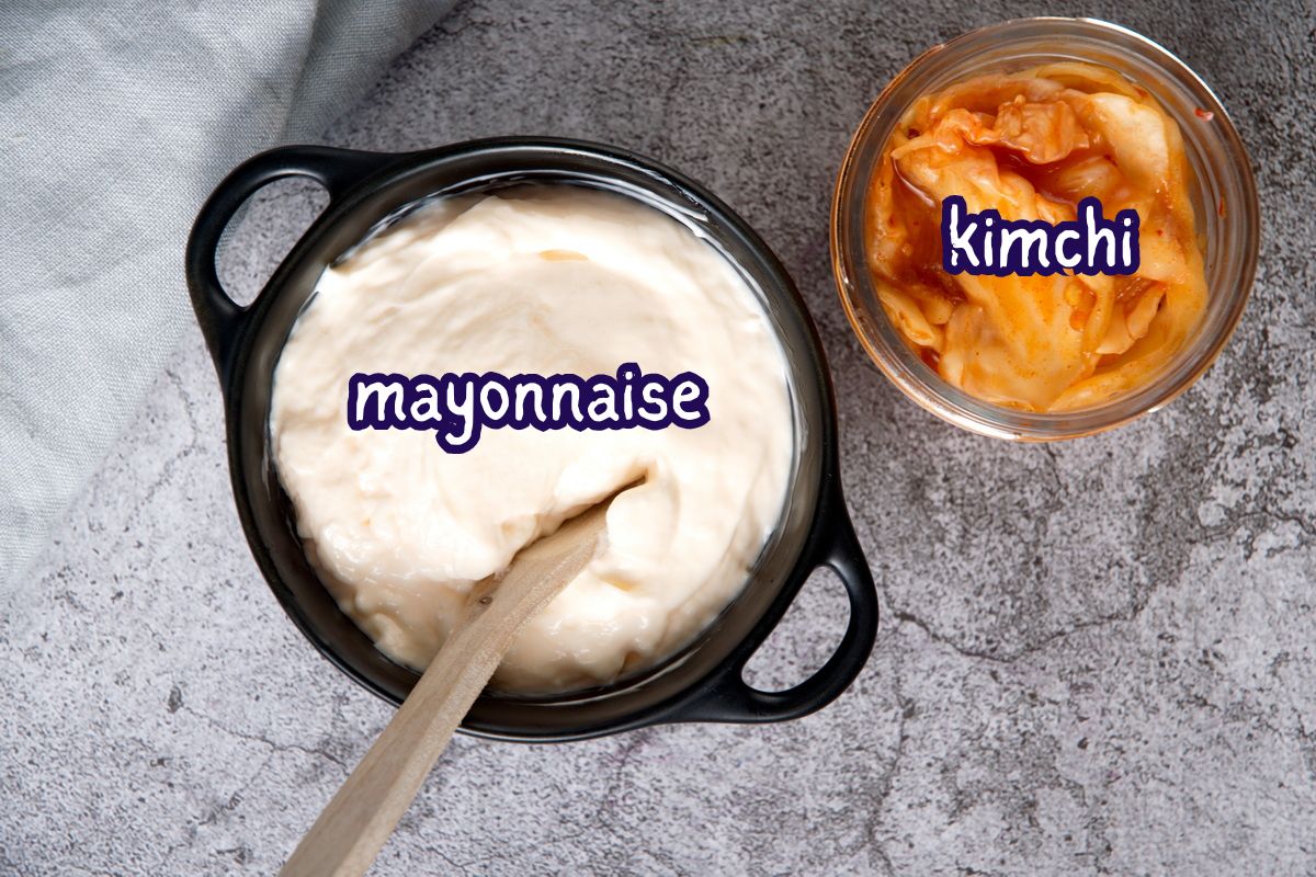 Kimchi in jar and mayo in small black dish labeled.