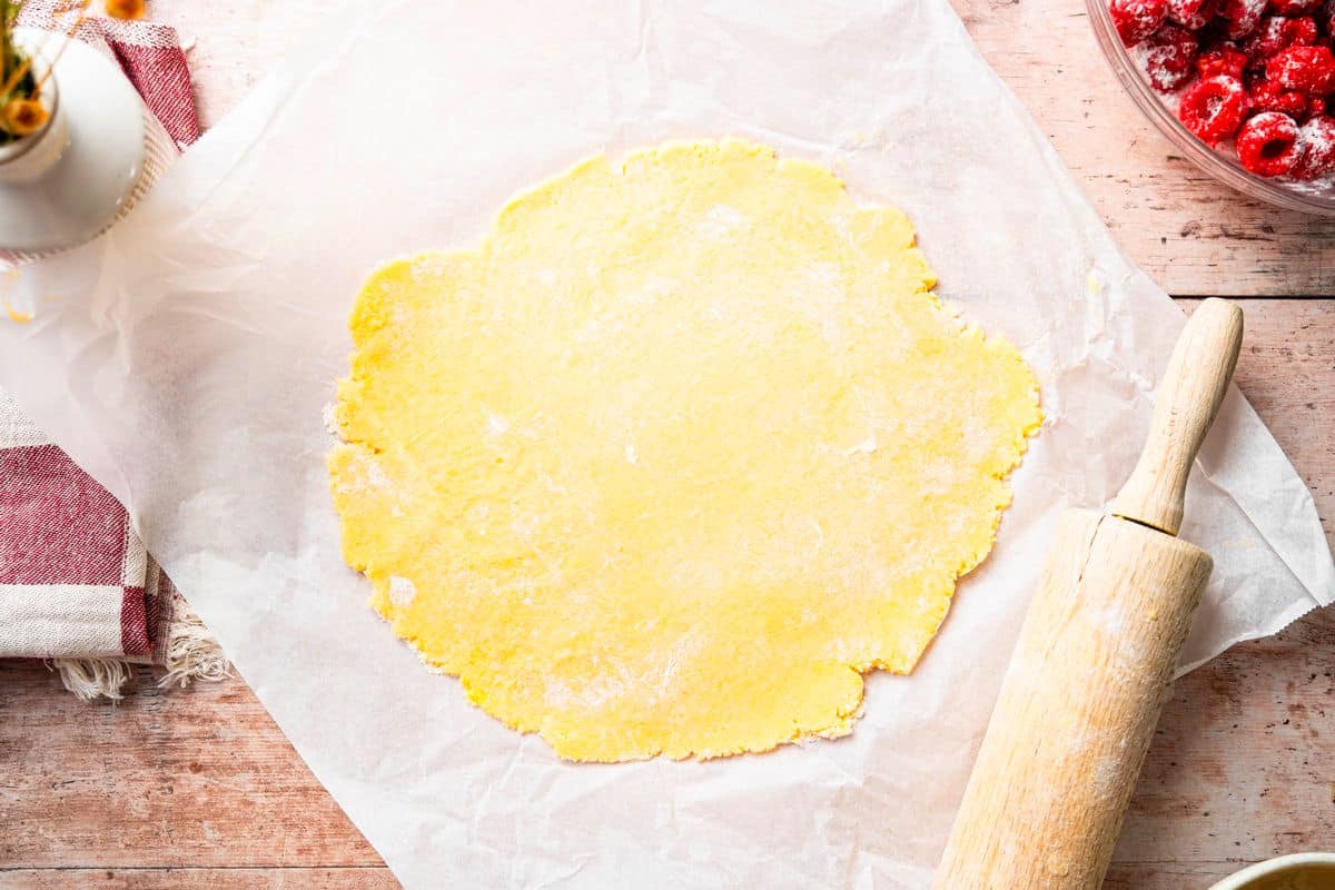 Galette pastry on parchment with rolling pin.
