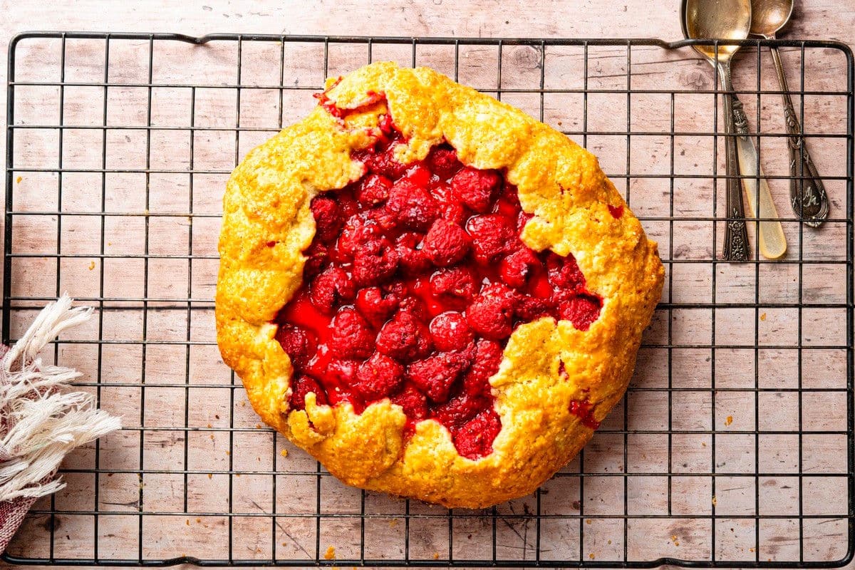 Baked raspberry galette cooling on baking rack.
