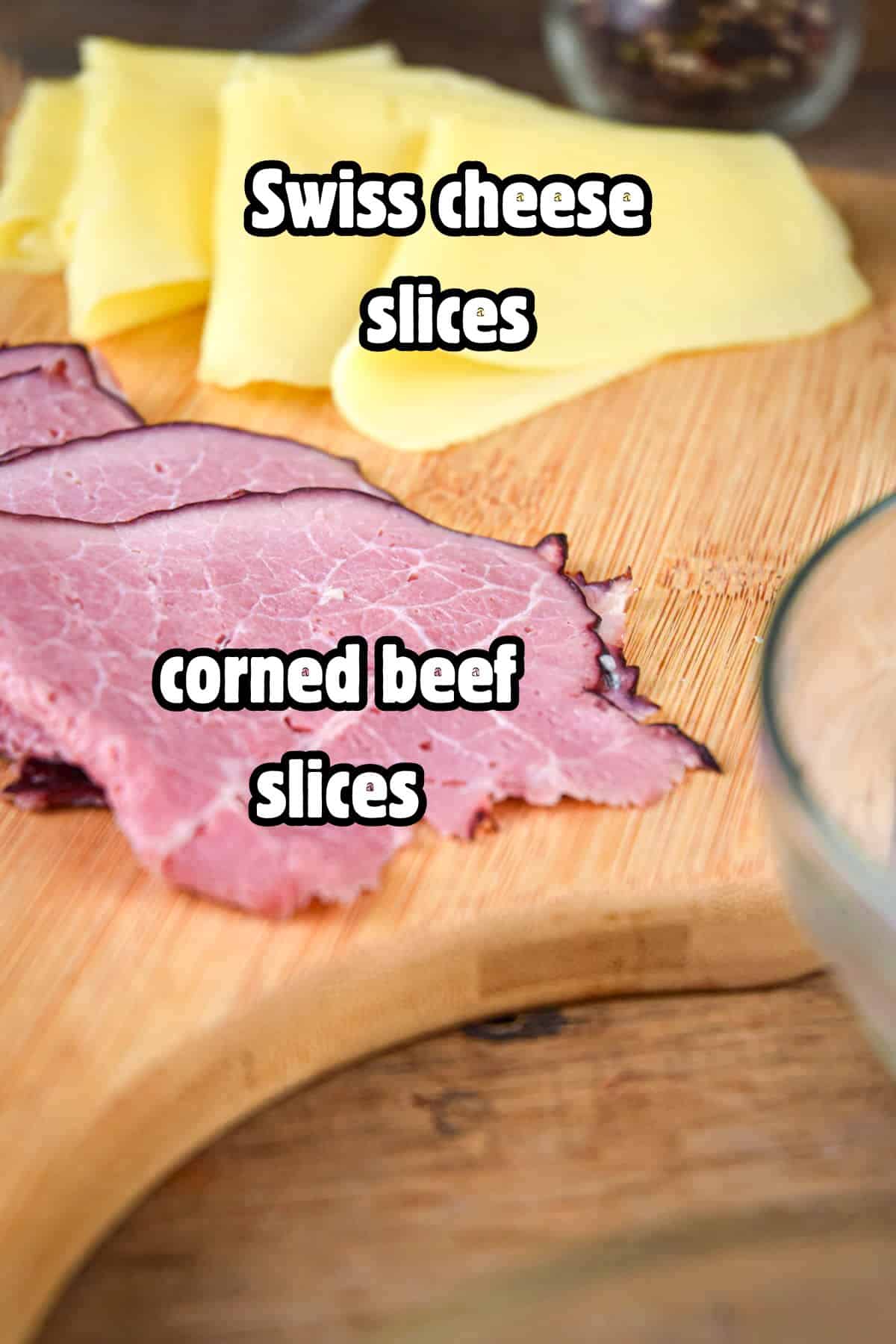 Swiss cheese and corned beef slices on board, labeled.