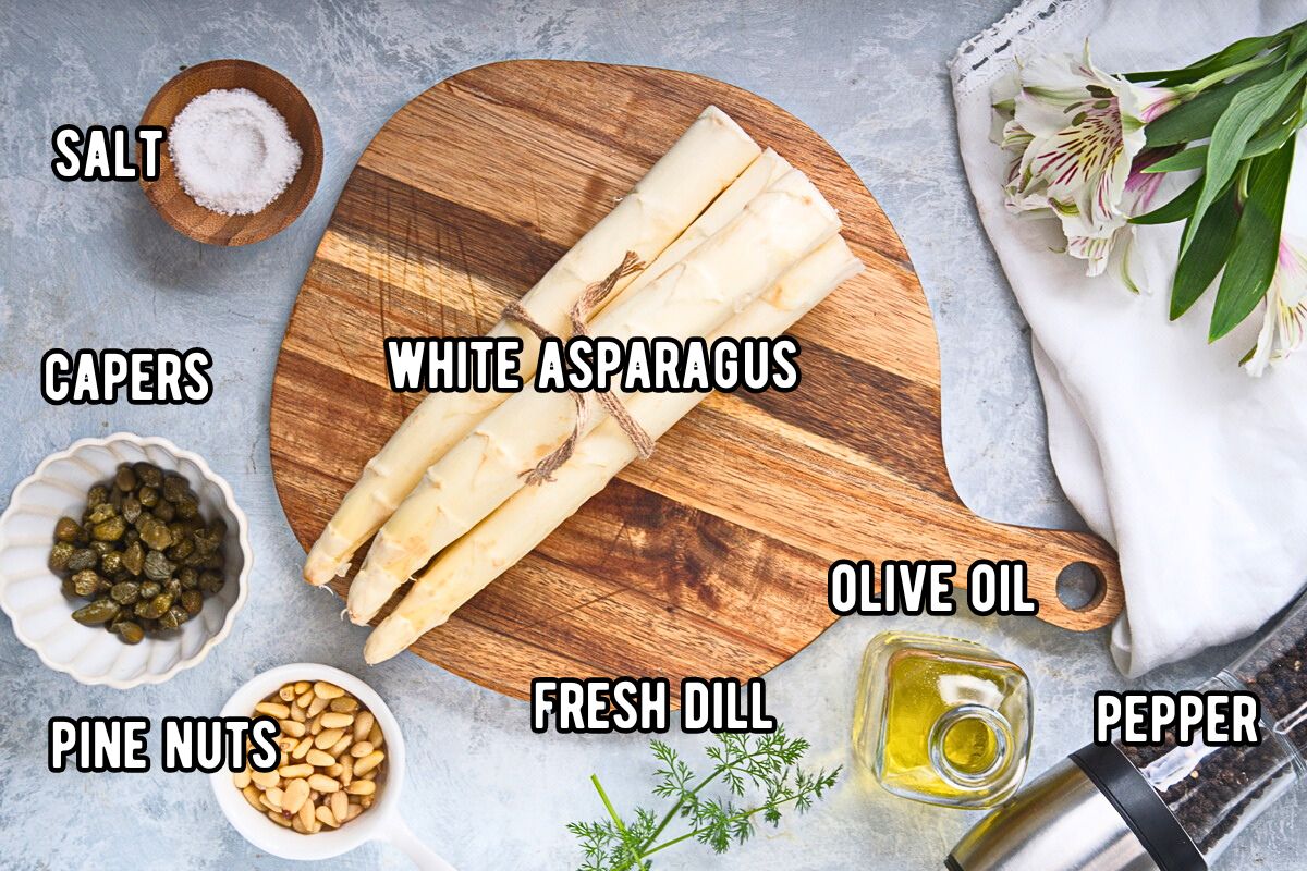 Roasted white asparagus ingredients prepped and labeled on light grey background.