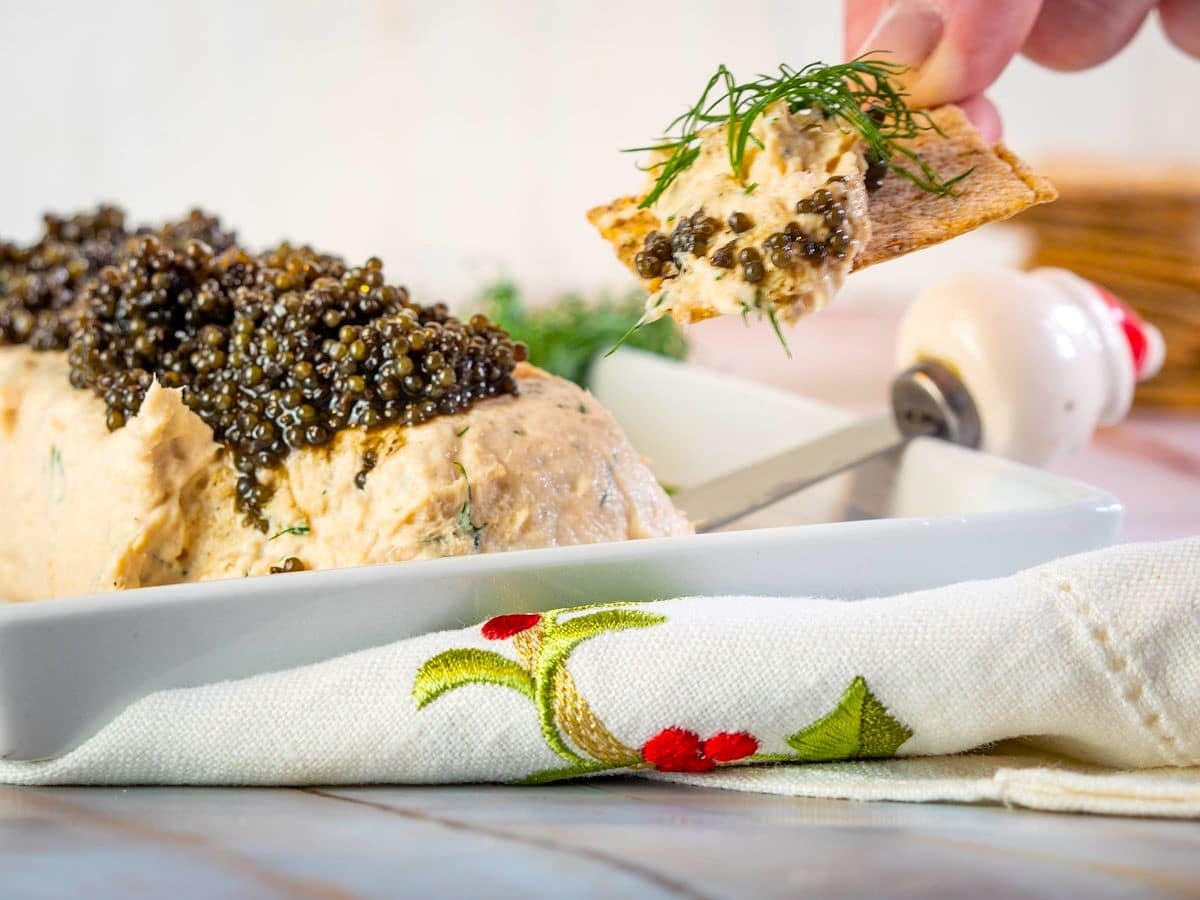Salmon and dill mousse with caviar in white dish.