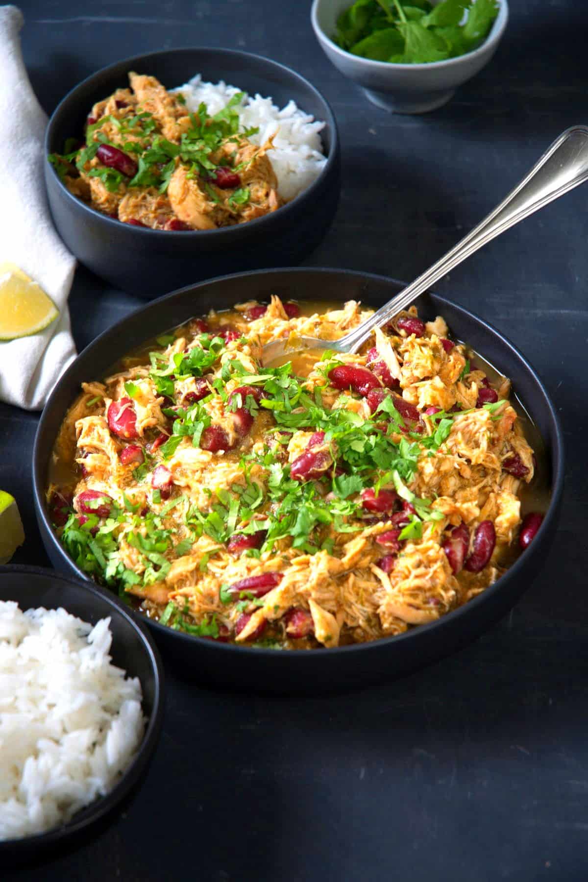 Mexican shredded chicken with salsa verde in bowls with spoon.