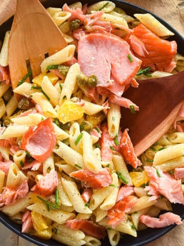 Smoked salmon pasta salad in black dish.