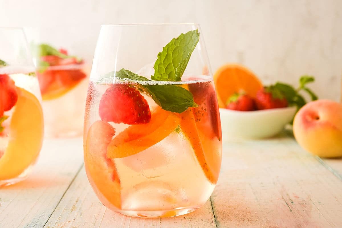 Spring white wine sangria in stemless wine glass.