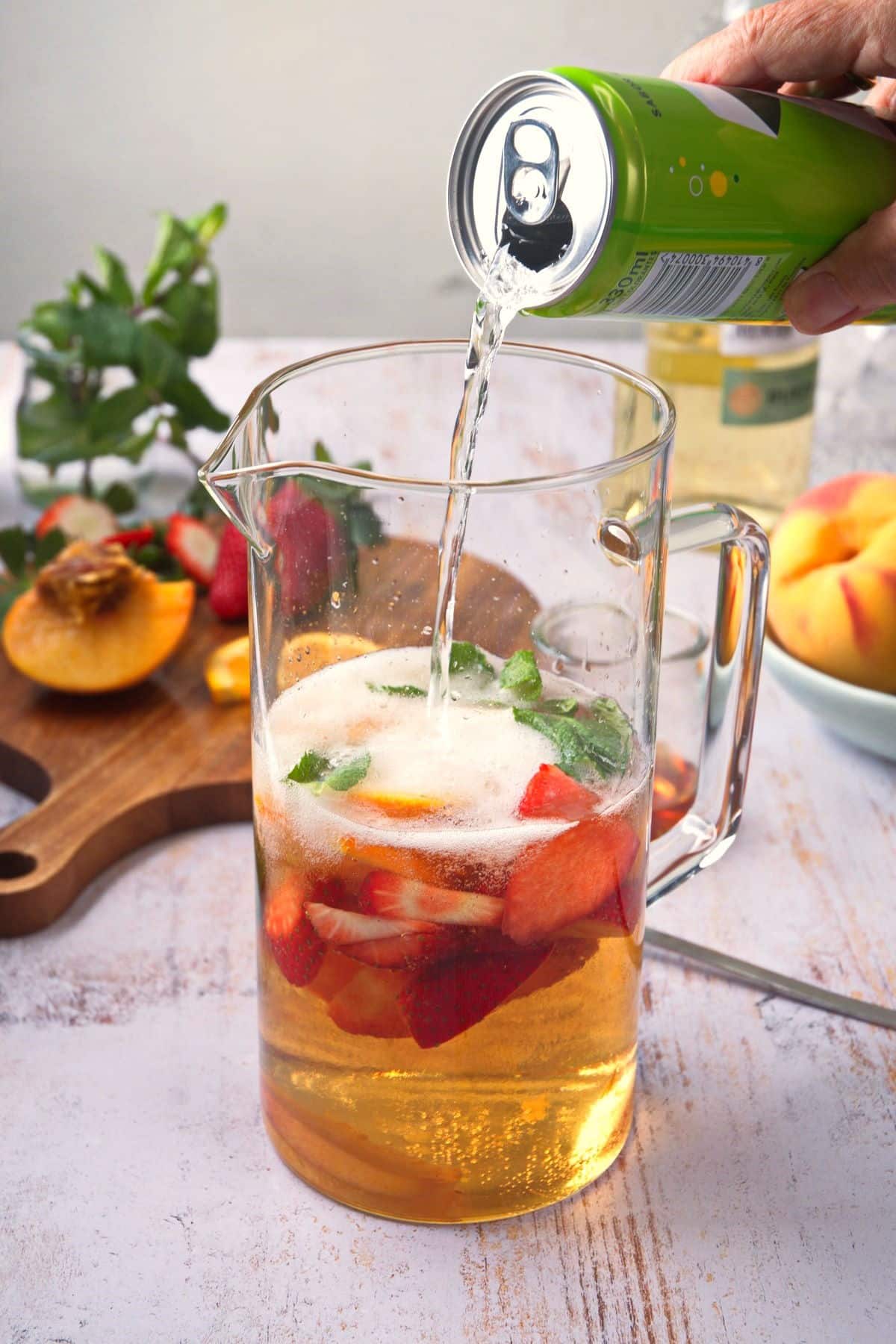 Spring sangria in glass pitcher with lemon-lime soda.