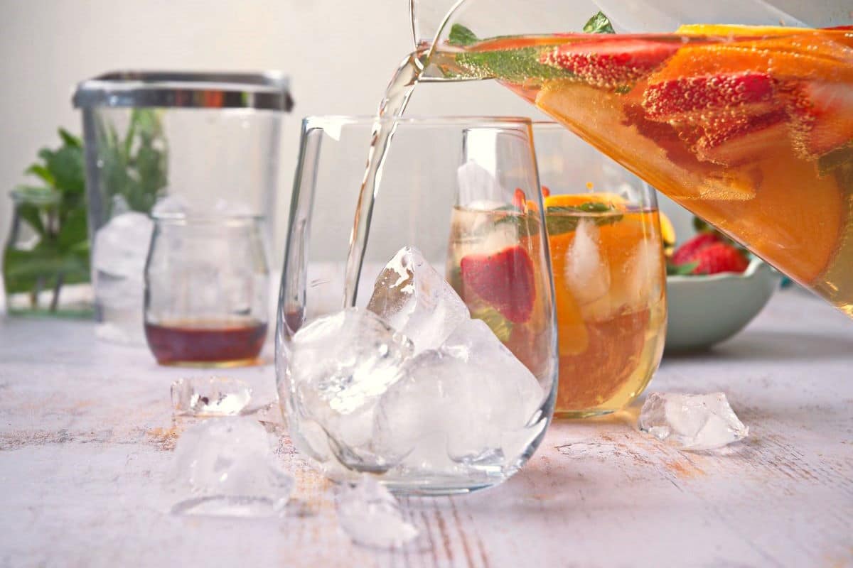 Spring sangria in pitcher and ice in wine glass.