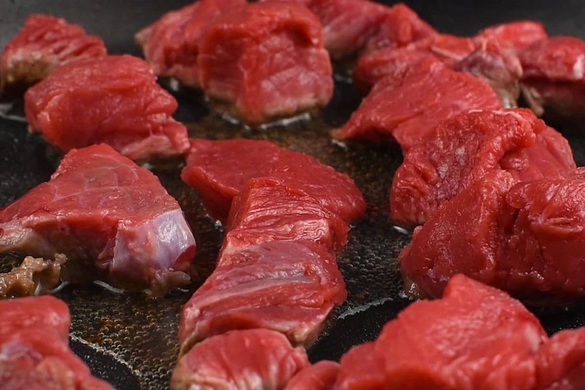 Beef cubes in electric skillet.