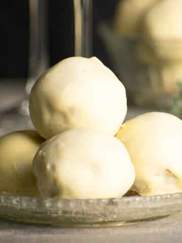 Strawberry champagne cake balls stacked on plate.