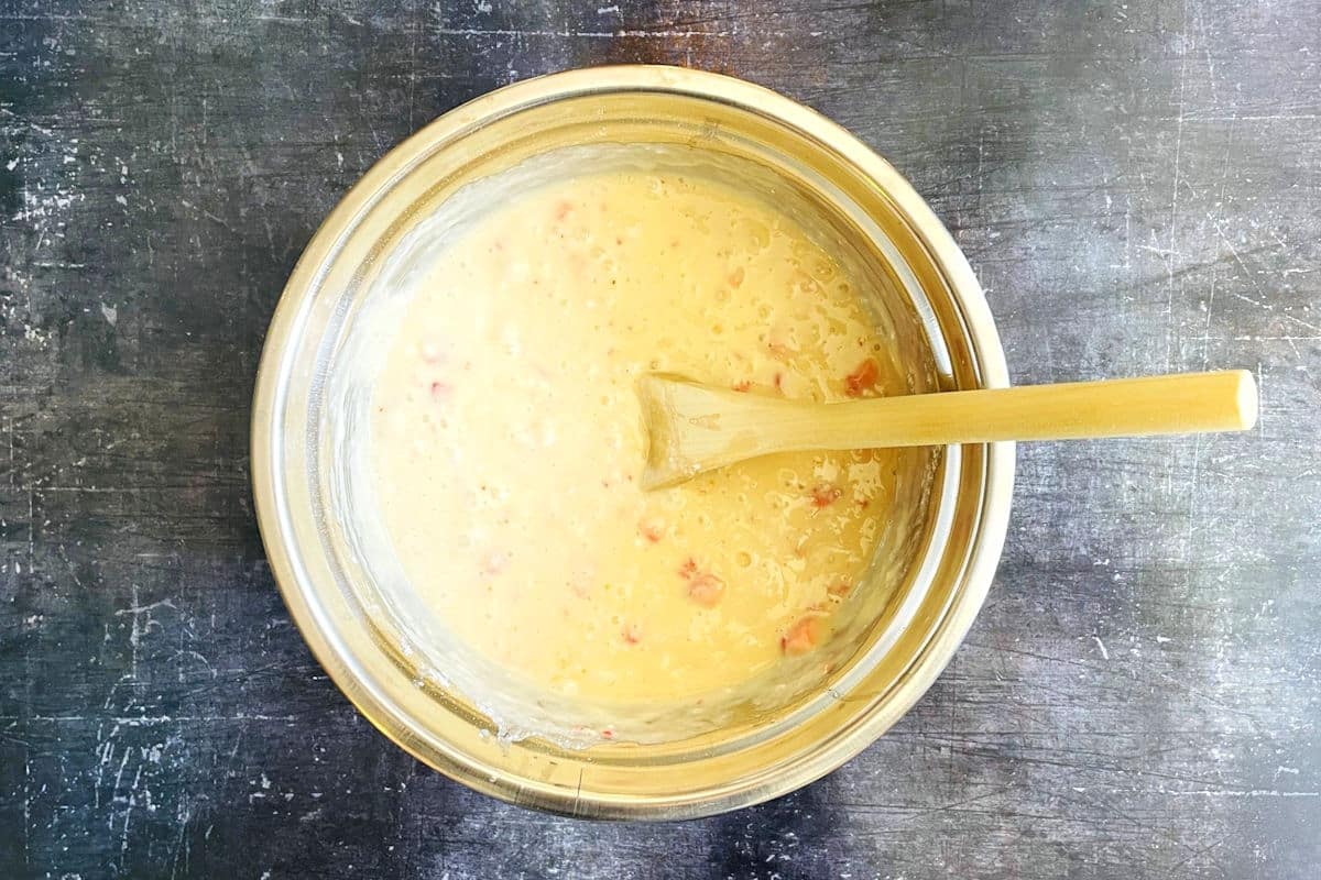 Strawberry champagne cake batter in bowl with wooden spoon.