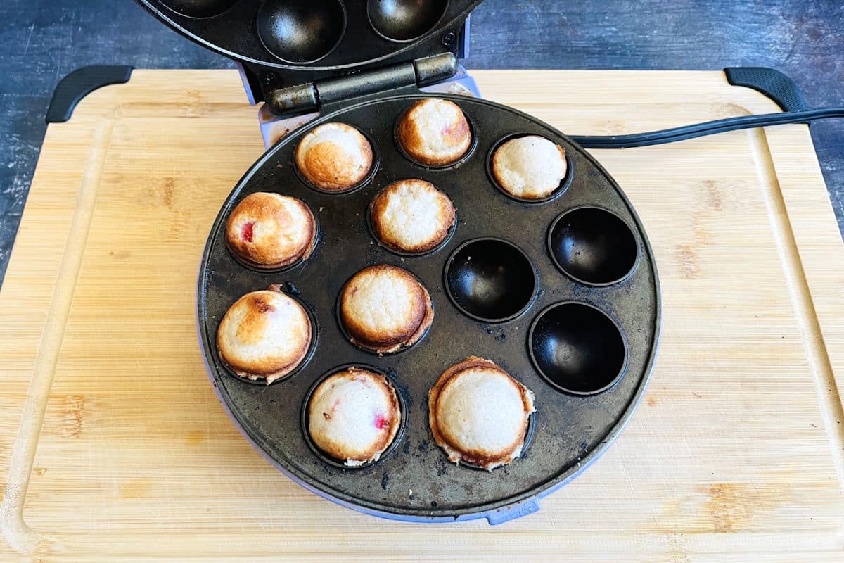 Strawberry champagne cake balls in cake pop maker.