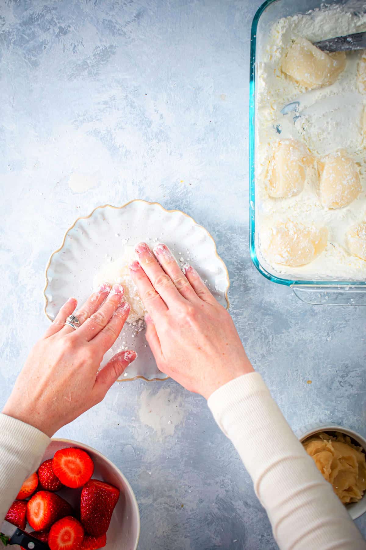 Mochi dough getting flattened on plate.