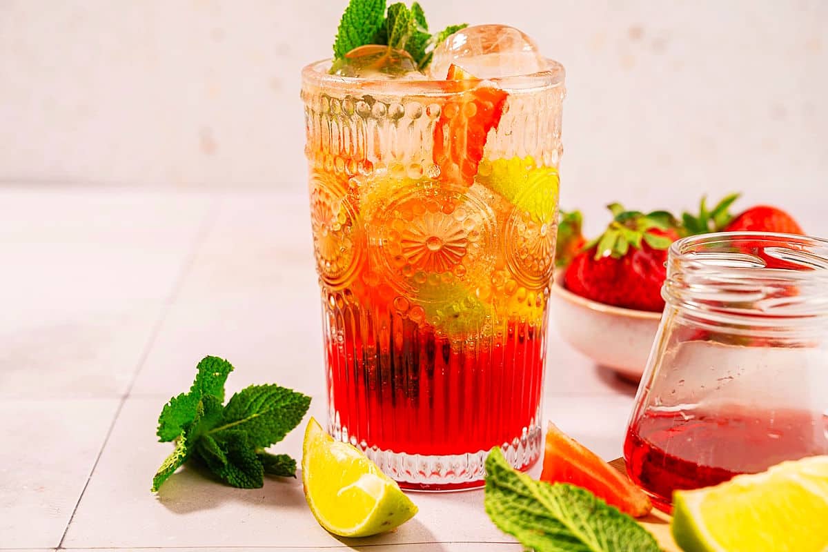 Strawberry mojito mocktail in glass with fresh mint on the side.