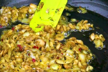 Mushrooms and onion filling cooking in pan.