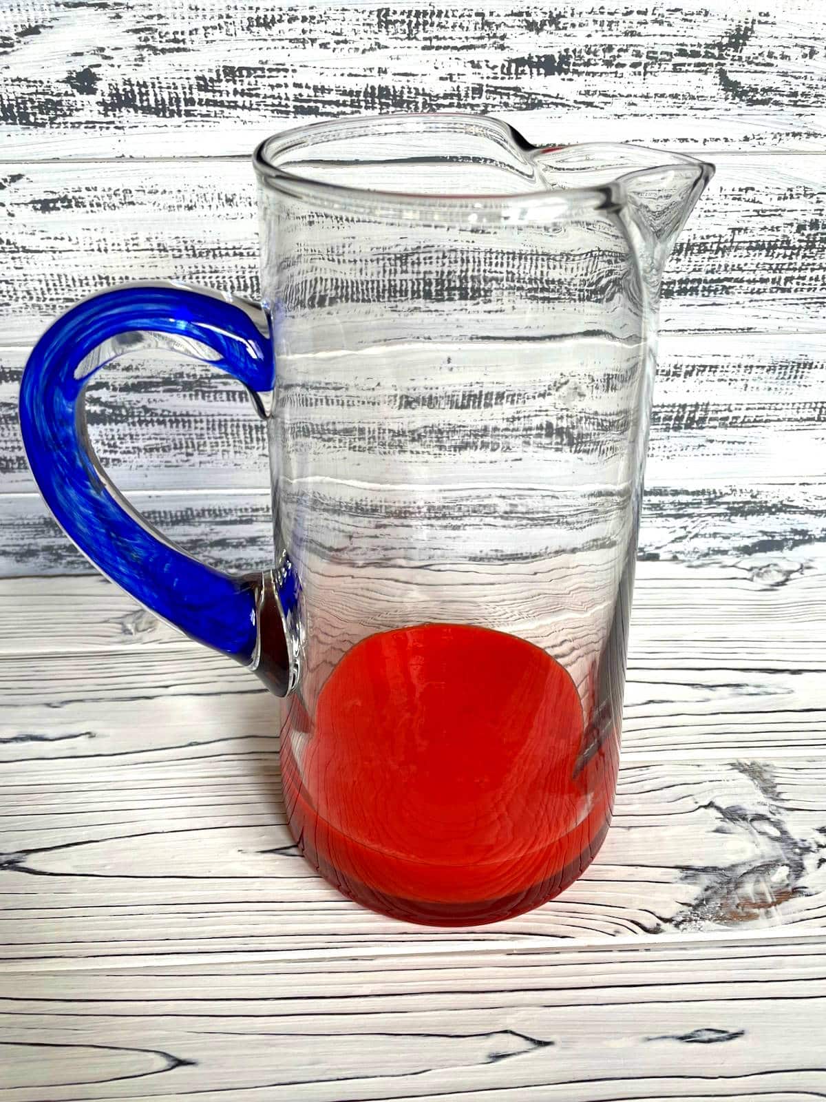 Mango pomegranate puree in glass pitcher.