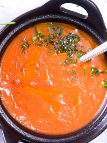 Tomato gravy in cast iron bowl with spoon.