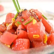 Tuna watermelon tartare on clear glass plate.
