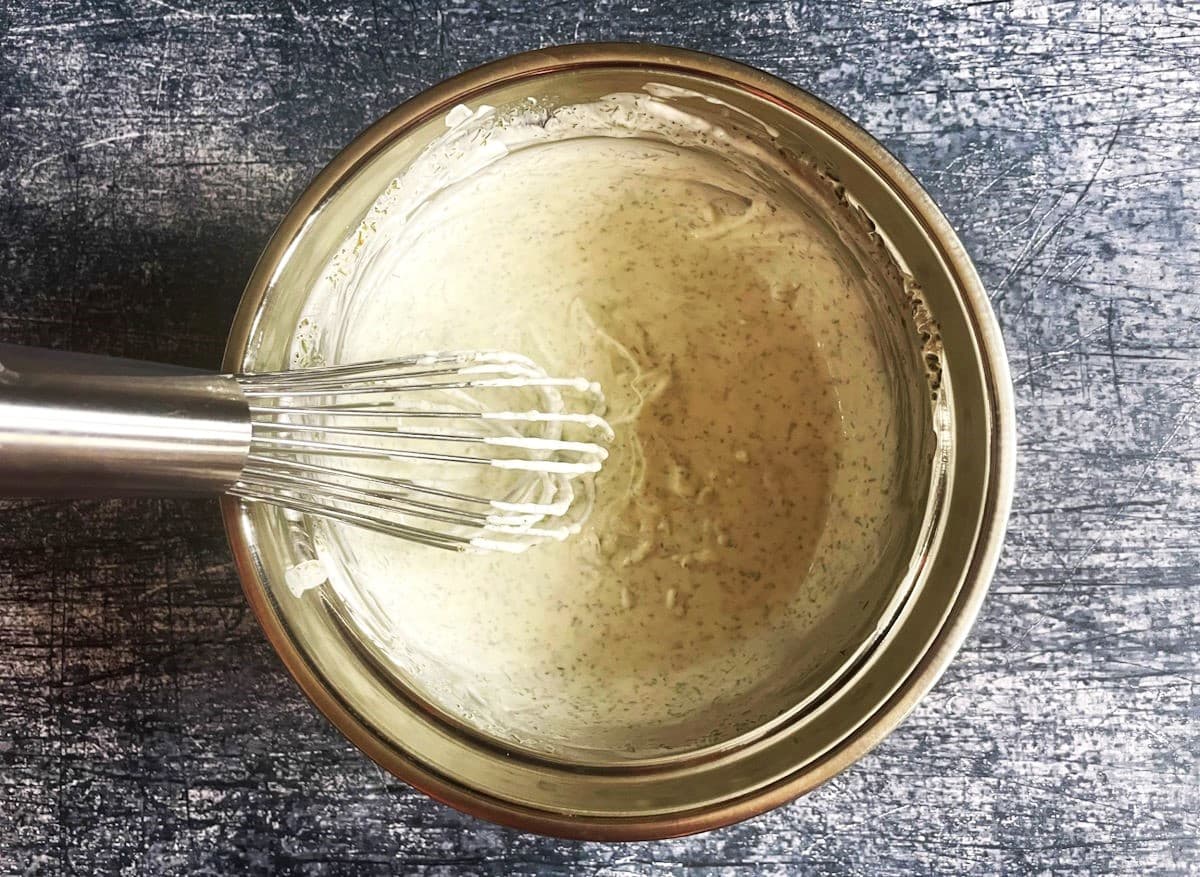Turnip fries dipping sauce in bowl with whisk.