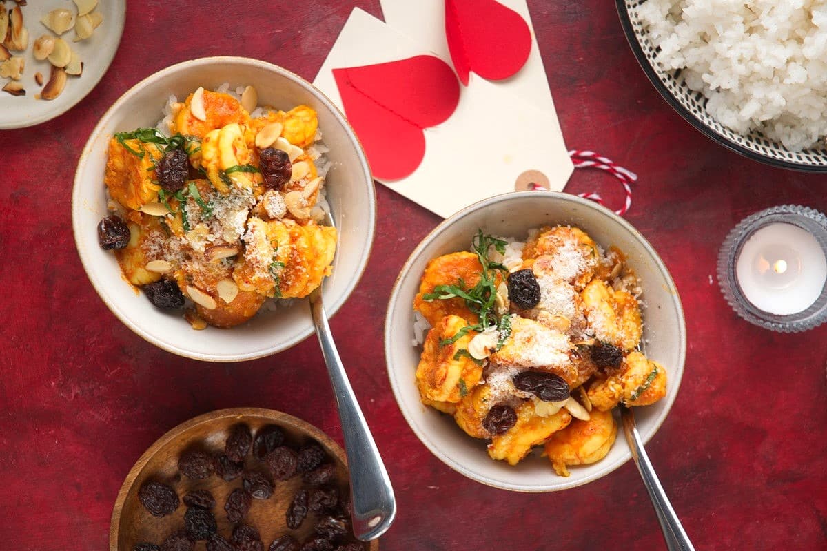 Shrimp curry in two bowls with Valentine's Day decorations.