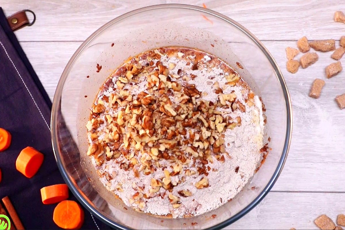 Carrot cupcake batter with pecans in bowl.