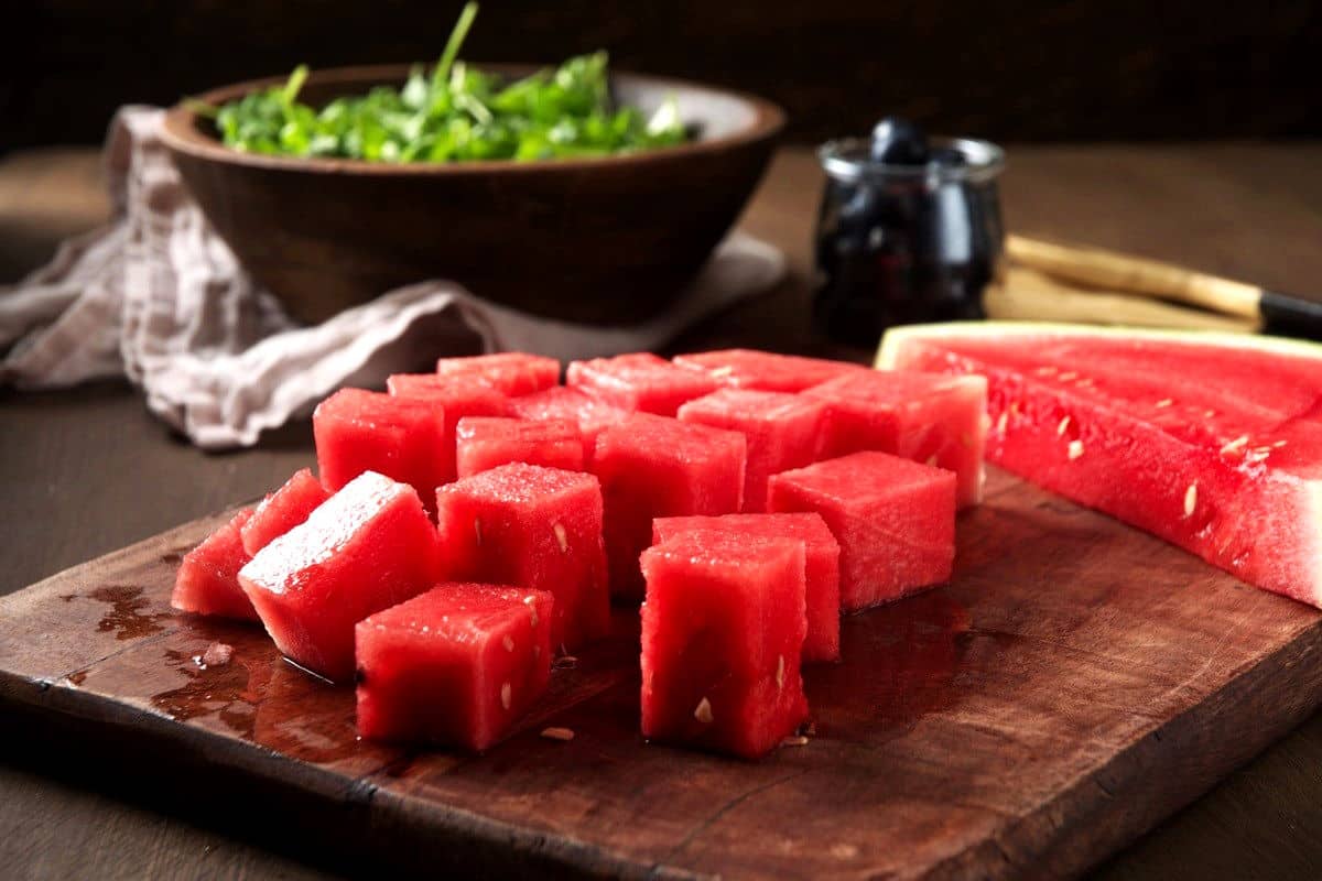 Watermelon cubes on cutting board.