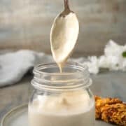 White BBQ sauce dripping from spoon.
