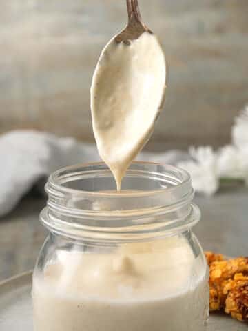 White BBQ sauce dripping from spoon.