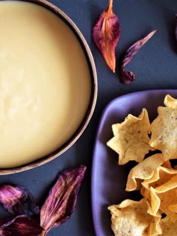 White cheddar nacho cheese sauce in bowl with tortilla chips.